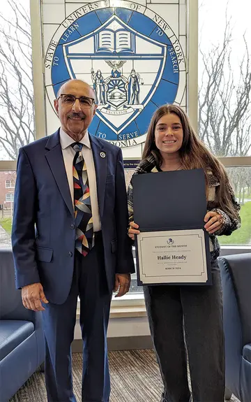 Hallie Heady, displaying her Student of the Month certificate, with Dr. Moj Seyedian, who nominated her for the award.