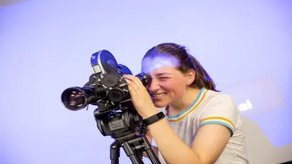 Fredonia student uses a camera, working in video arts, majoring in visual arts.