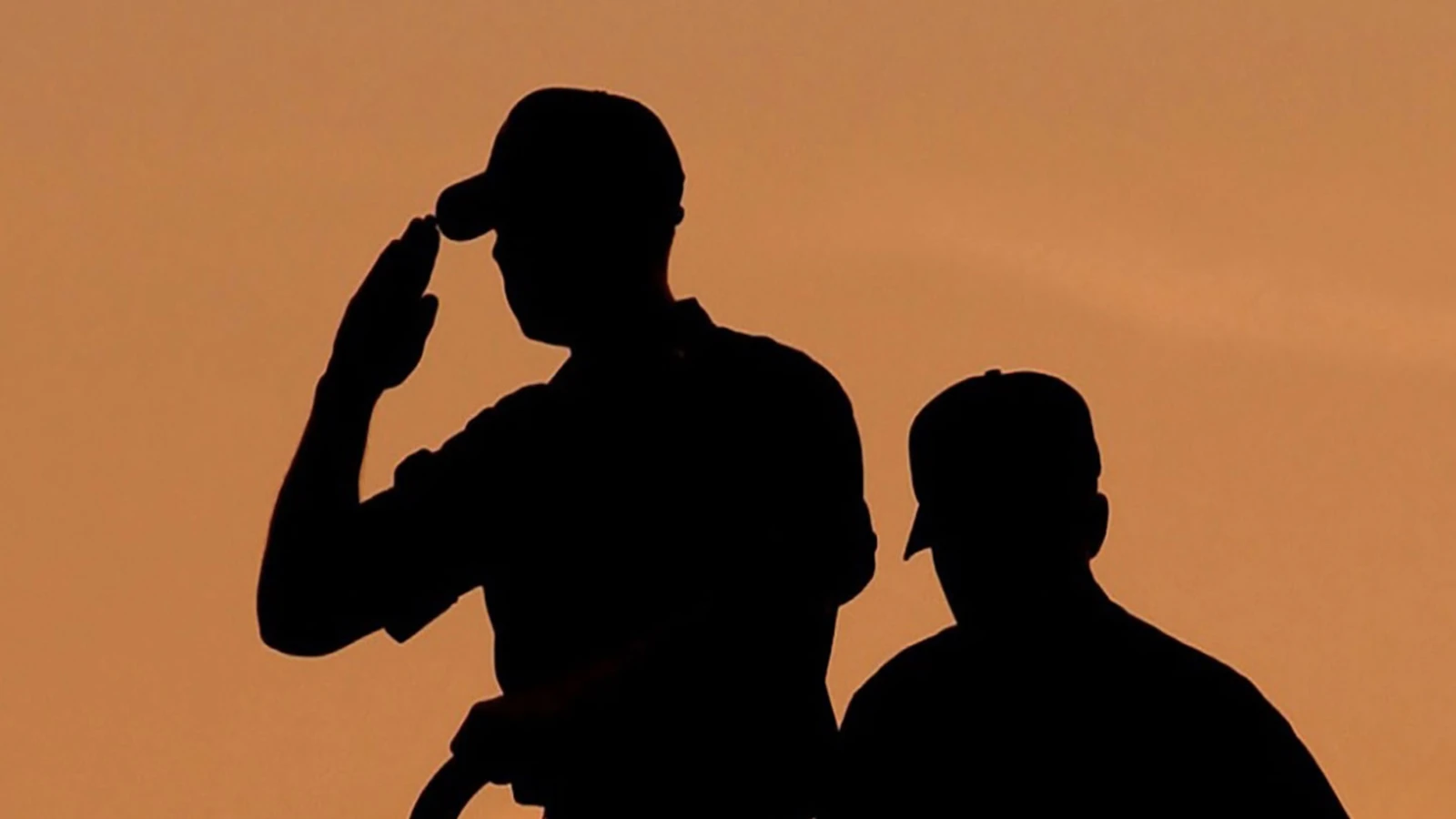 Silouette of military people, with one saluting.