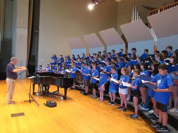 Dr. Vernon Huff conducts youngsters singing on King Concert Hall stage.