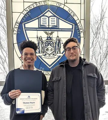 Thomas Hayes (left) displays his Resident Assistant of the Month certificate with Grissom Hall Residence Director Kyle Piscitelli.