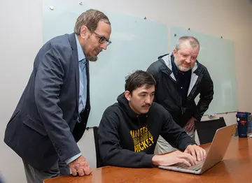 Alim Darmenov reviewing The Hospital Locator with Dr. Junaid Zubairi (left) and Charles Cornell, certified business incubator manager at the Center for Innovation & Economic Development, where the hospital app was created.