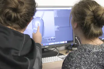 students look a a computer screen working on an animation project
