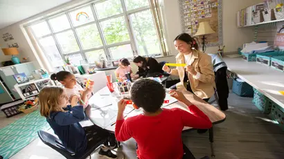 A first-year student in the college of education works with elementary students at a local school.